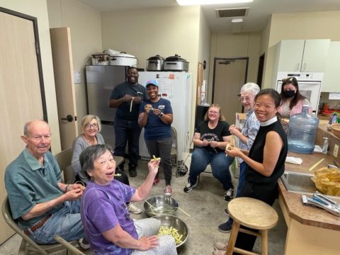 The St. Alban's altar guild teaching the Rev. Peggy Lo to make palm crosses.