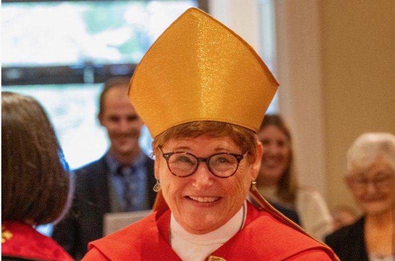 Bishop Ritonia, wearing a gold mitre and red cassock, at her consecration