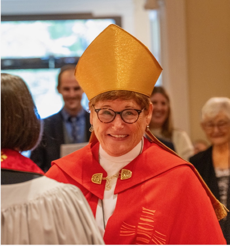 Bishop Ritonia, wearing a gold mitre and red cassock, at her consecration